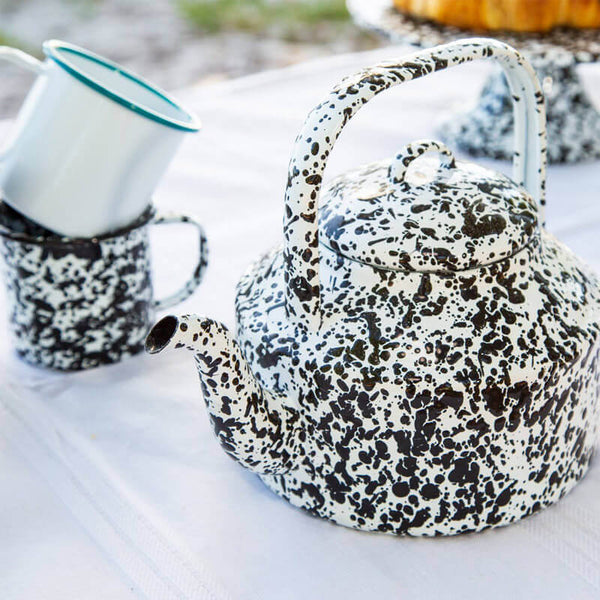 Crop view of female holding porcelain teapot and pouring hot tea into red  ceramic polka-dotted?